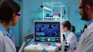 Professional chemists analysing vaccine development using touchscreen display in equipped laboratory overwork. Nurse examining virus evolution using high tech researching diagnosis against covid19 video