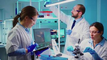 Nurses analysing together virus mutations working overtime in chemistry equipped laboratory. Group of doctors examining vaccine evolution using high tech researching diagnosis against covid19 video