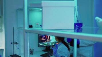 Scientists coworkers working in chemical modern equipped laboratory at night analysing test results. Stuff examining vaccine evolution using high tech researching treatment against covid19 virus video