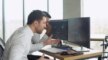 Indian and caucasian traders dissapointed by the stock or cryptocurrency market fall. Bitcoin falling. Cryptocurrency market crash. Bitcoin downtrend. Crisis of cryptocurrency video