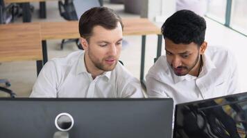 Two men traders sitting at desk at office together monitoring stocks data candle charts money flow on screen concentrated teamwork discussing strategy concept video