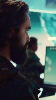 Vertical Army IT professional examining national satellite surveillance footage, transmitting real time important information from base to the general headquarters. General of the navy operations. Camera B. video