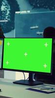 Vertical Intelligence analyst reviews ships activity next to an isolated mockup screen, following gps coordinates of vessels anchoring along the coastal ports. Army officer in monitoring room. Camera B. video