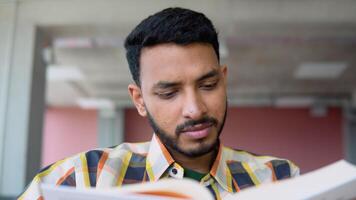 Indian or Pakistani student reads a book in a university library. Preparing to the exams video
