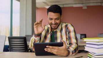 Indian smiling student using a tablet, study a simple Internet course, online learning in the application, write notes, prepare for the exam, watch educational . chat with the teacher video