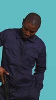 Vertical Portrait of security staff member tasked with evicting trespassers, intimidating them with baton. Patrolling agent maintains secure environment using truncheon weapon, studio background, camera B video