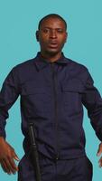 Vertical Portrait of security agent doing crowd control, securing assigned post, studio background. African american guardian pushing back unwanted trespassers, handling security breaches, camera B video