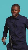 Vertical Portrait of security staff member tasked with evicting trespassers turns on flashlight. Patrolling agent maintains secure environment with lantern device, spotting people, studio background, camera B video