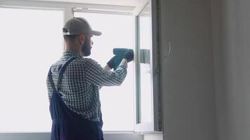 Man in uniform does pvc window installation with a screwdriver video