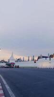 vertical timelapse street view at grand royal palace of Bangkok with many traffic in long expossure light tail technique in sunset with beautiful vanila skytime. video