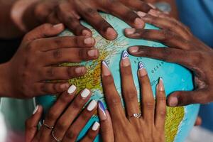 Close up of diverse teenagers' hands delicately exploring a globe, capturing the essence of curiosity and exploration in their tactile engagement with geographical knowledge photo