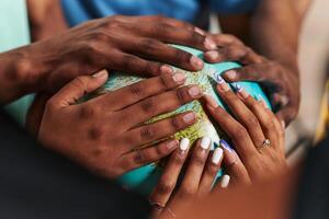 Close up of diverse teenagers' hands delicately exploring a globe, capturing the essence of curiosity and exploration in their tactile engagement with geographical knowledge photo