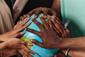 Close up of diverse teenagers' hands delicately exploring a globe, capturing the essence of curiosity and exploration in their tactile engagement with geographical knowledge photo