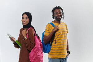 Against a clean white background, two students, an African American young man and a hijab-wearing woman, collaboratively use laptops in a display of technological empowerment and inclusive education photo