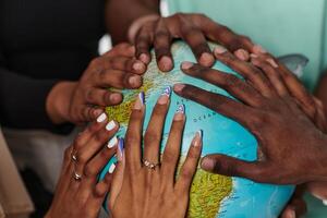 Close up of diverse teenagers' hands delicately exploring a globe, capturing the essence of curiosity and exploration in their tactile engagement with geographical knowledge photo