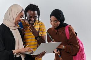 A group of students, including an African American student and two hijab-wearing women, stand united against a pristine white background, symbolizing a harmonious blend of cultures and backgrounds in photo