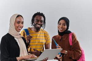 A group of students, including an African American student and two hijab-wearing women, stand united against a pristine white background, symbolizing a harmonious blend of cultures and backgrounds in photo