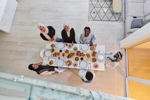 Top view of a Muslim family joyously comes together around a table, eagerly awaiting the communal iftar, engaging in the preparation of a shared meal, and uniting in anticipation of a collective photo