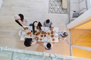 Top view of a Muslim family joyously comes together around a table, eagerly awaiting the communal iftar, engaging in the preparation of a shared meal, and uniting in anticipation of a collective photo