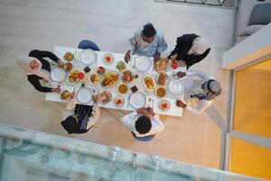 Top view of a Muslim family joyously comes together around a table, eagerly awaiting the communal iftar, engaging in the preparation of a shared meal, and uniting in anticipation of a collective photo