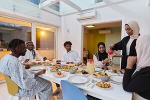 In the sacred month of Ramadan, a Muslim family joyously comes together around a table, eagerly awaiting the communal iftar, engaging in the preparation of a shared meal, and uniting in anticipation photo