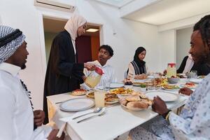 In the sacred month of Ramadan, a Muslim family joyously comes together around a table, eagerly awaiting the communal iftar, engaging in the preparation of a shared meal, and uniting in anticipation photo