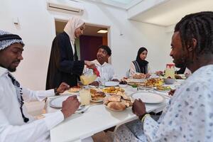In the sacred month of Ramadan, a Muslim family joyously comes together around a table, eagerly awaiting the communal iftar, engaging in the preparation of a shared meal, and uniting in anticipation photo