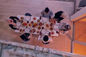 Top view of a Muslim family joyously comes together around a table, eagerly awaiting the communal iftar, engaging in the preparation of a shared meal, and uniting in anticipation of a collective photo