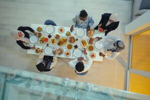 Top view of a Muslim family joyously comes together around a table, eagerly awaiting the communal iftar, engaging in the preparation of a shared meal, and uniting in anticipation of a collective photo