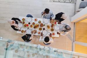 Top view of a Muslim family joyously comes together around a table, eagerly awaiting the communal iftar, engaging in the preparation of a shared meal, and uniting in anticipation of a collective photo
