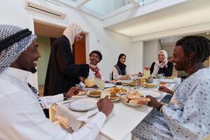 In the sacred month of Ramadan, a Muslim family joyously comes together around a table, eagerly awaiting the communal iftar, engaging in the preparation of a shared meal, and uniting in anticipation photo