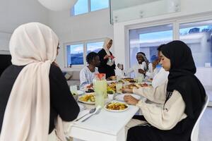 In the sacred month of Ramadan, a Muslim family joyously comes together around a table, eagerly awaiting the communal iftar, engaging in the preparation of a shared meal, and uniting in anticipation photo