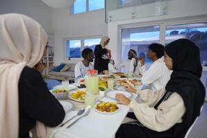 In the sacred month of Ramadan, a Muslim family joyously comes together around a table, eagerly awaiting the communal iftar, engaging in the preparation of a shared meal, and uniting in anticipation photo