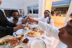In a poignant close-up, the diverse hands of a Muslim family delicately grasp fresh dates, symbolizing the breaking of the fast during the holy month of Ramadan, capturing a moment of cultural unity photo