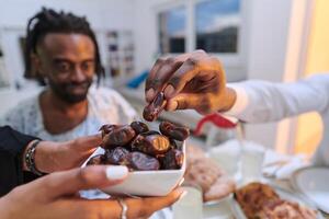 In a poignant close-up, the diverse hands of a Muslim family delicately grasp fresh dates, symbolizing the breaking of the fast during the holy month of Ramadan, capturing a moment of cultural unity photo