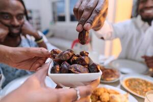 In a poignant close-up, the diverse hands of a Muslim family delicately grasp fresh dates, symbolizing the breaking of the fast during the holy month of Ramadan, capturing a moment of cultural unity photo