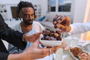 In a poignant close-up, the diverse hands of a Muslim family delicately grasp fresh dates, symbolizing the breaking of the fast during the holy month of Ramadan, capturing a moment of cultural unity photo