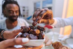 In a poignant close-up, the diverse hands of a Muslim family delicately grasp fresh dates, symbolizing the breaking of the fast during the holy month of Ramadan, capturing a moment of cultural unity photo