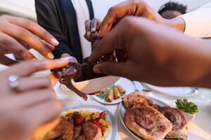 In a poignant close-up, the diverse hands of a Muslim family delicately grasp fresh dates, symbolizing the breaking of the fast during the holy month of Ramadan, capturing a moment of cultural unity photo