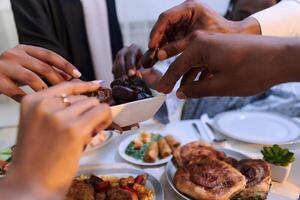 In a poignant close-up, the diverse hands of a Muslim family delicately grasp fresh dates, symbolizing the breaking of the fast during the holy month of Ramadan, capturing a moment of cultural unity photo