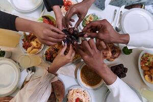In a poignant close-up, the diverse hands of a Muslim family delicately grasp fresh dates, symbolizing the breaking of the fast during the holy month of Ramadan, capturing a moment of cultural unity photo