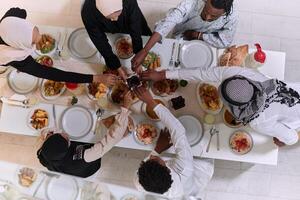 Top view of diverse hands of a Muslim family delicately grasp fresh dates, symbolizing the breaking of the fast during the holy month of Ramadan, capturing a moment of cultural unity, shared tradition photo