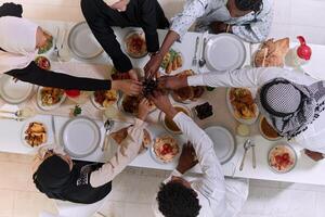 Top view of diverse hands of a Muslim family delicately grasp fresh dates, symbolizing the breaking of the fast during the holy month of Ramadan, capturing a moment of cultural unity, shared tradition photo