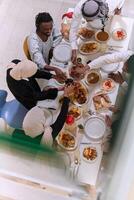 Top view of diverse hands of a Muslim family delicately grasp fresh dates, symbolizing the breaking of the fast during the holy month of Ramadan, capturing a moment of cultural unity, shared tradition photo