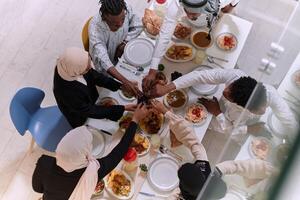 Top view of diverse hands of a Muslim family delicately grasp fresh dates, symbolizing the breaking of the fast during the holy month of Ramadan, capturing a moment of cultural unity, shared tradition photo