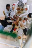 Top view of diverse hands of a Muslim family delicately grasp fresh dates, symbolizing the breaking of the fast during the holy month of Ramadan, capturing a moment of cultural unity, shared tradition photo