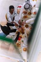 Top view of diverse hands of a Muslim family delicately grasp fresh dates, symbolizing the breaking of the fast during the holy month of Ramadan, capturing a moment of cultural unity, shared tradition photo