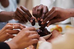 In a poignant close-up, the diverse hands of a Muslim family delicately grasp fresh dates, symbolizing the breaking of the fast during the holy month of Ramadan, capturing a moment of cultural unity photo