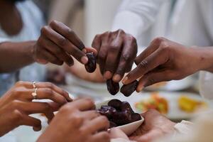 In a poignant close-up, the diverse hands of a Muslim family delicately grasp fresh dates, symbolizing the breaking of the fast during the holy month of Ramadan, capturing a moment of cultural unity photo