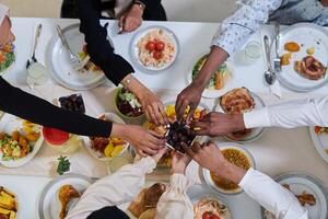 Top view of diverse hands of a Muslim family delicately grasp fresh dates, symbolizing the breaking of the fast during the holy month of Ramadan, capturing a moment of cultural unity, shared tradition photo